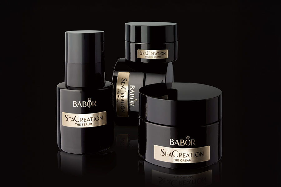 Vier schwarze BABOR SeaCreation Produkte nebeneinander und aufeinander gestapelt